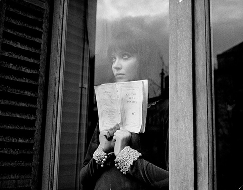 alphaville-1965-006-anna-karina-behind-glass-door-holding-book-00o-4cd